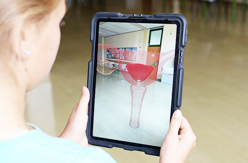 Menstruation im Unterricht Mädchen sieht Gebärmutter in Augmented Reality am Tablet